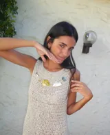 Vestido largo de crochet en color azul marino, con diseño sin mangas y cuello redondo. Presenta un detalle de apliques metálicos en la zona del pecho y un ruedo con volado de textura contrastante.