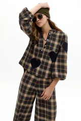Camisa oversized de algodón con estampado de cuadros en tonos marrones y azules. Presenta cuello mao, cierre frontal con botones de nácar, mangas largas abullonadas con puños elásticos y apliques decorativos en forma de corazón de lana en el frente y las mangas.