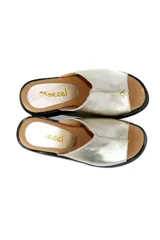 Zueco con plataforma de cuero negro con estampado croco en tonos dorados.