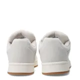 Championes de estilo urbano con diseño bicolor en negro y blanco, confeccionados en material tipo gamuza con cordones anchos blancos y suela de goma color caramelo.