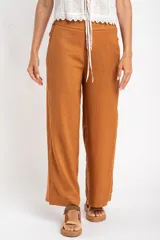 Pantalón de lino color tostado, de corte recto y tiro medio.