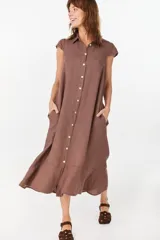Vestido midi color azul de lino italiano, con diseño camisero, cuello camisero, mangas cortas abullonadas, cierre frontal con botones y bolsillos laterales.