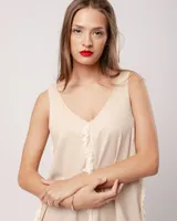 Vestido largo blanco de lino con escote en V y flecos de algodón en los bordes.