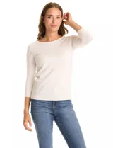 Buzo de tejido fino en color blanco, con cuello redondo y mangas tres cuartos tipo raglán. Presenta un detalle decorativo de tachas metálicas a lo largo de las mangas.