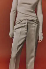 Pantalón sastrero de tiro alto y pierna recta, color blanco, con raya marcada al frente y en la espalda, bolsillos laterales al bies y bolsillos traseros decorativos.
