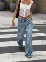 Corset de encaje negro con diseño floral, copas estructuradas y cierre frontal con botones a presión. Presenta breteles anchos de encaje y espalda con diseño de red.