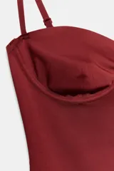 Body lencero color bordó de poliamida, con escote corazón con aro, tirantes finos regulables y cierre inferior a presión.