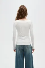 Top de manga larga color blanco, con cuello redondo amplio y ajuste al cuerpo.