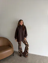 Pantalón tipo oxford de tiro alto, con estampado abstracto en tonos tierra, negro y crema. Presenta un corte ajustado en la parte superior y acampanado desde la rodilla hacia abajo.