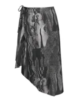 Falda asimétrica envolvente de silueta fluida, confeccionada en tela liviana con estampado gráfico en tonos negro y gris. Presenta ajuste lateral con tiras y diseño de largo irregular.