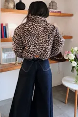 Campera puffer corta con estampado animal print de leopardo, cuello alto y cierre frontal. Diseño acolchado de corte holgado.