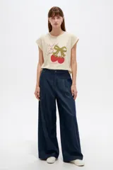 Remera de algodón color beige, de cuello redondo y manga corta con vuelta fija. Presenta un estampado frontal con la leyenda 'Fruit of The Soul' y un diseño de frutillas con un moño verde.