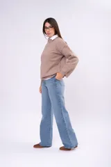 Sweater de punto liso en color beige, con cuello redondo, mangas largas y calce relajado.
