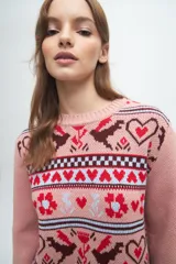 Buzo tejido de punto con diseño jacquard que presenta motivos de corazones, flores y aves en tonos bordó, blanco y celeste. Posee cuello redondo, puños y ruedo acanalados.