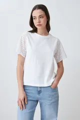 Remera fucsia de manga corta con detalle de broderie en las mangas.