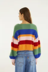 Sweater cropped de tejido de punto con acabado afelpado y diseño de rayas multicolor. Presenta cuello redondo, mangas largas y silueta amplia, combinando textura suave con un estilo vibrante y moderno.