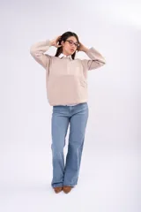 Sweater de punto liso en color beige, con cuello redondo, mangas largas y calce relajado.
