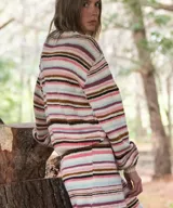 Sweater tejido a mano en lana merino, con diseño de rayas horizontales en tonos blancos, marrones, rosados y celestes, de corte cómodo, cuello redondo base y mangas largas.