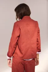 Chaqueta de lino lavado color blanco, con cuello mao, cierre metálico diagonal y detalles en contratono.
