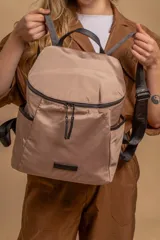 Mochila urbana de diseño compacto en color negro, confeccionada en nylon resistente. Cuenta con un compartimento principal con cierre, bolsillo frontal con cierre y correas ajustables con detalle de marca.