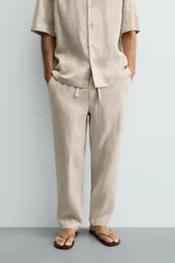 Pantalón relaxed fit de lino color negro, con cintura elástica ajustable con cordón y bolsillos frontales.