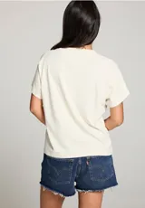 Remera color crema de algodón con estampado retro de cartas de póker, arcoíris y la frase "Viva Las Vegas".