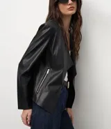 Campera de cuero sintético (PU) color negro, con diseño de solapas delanteras abiertas, mangas largas y corte recto. Presenta detalles de recortes a láser en la superficie.