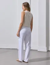 Pantalón de lino color blanco, de corte recto y tiro alto. Presenta bolsillos laterales tipo cargo y pretina elastizada en la parte trasera.