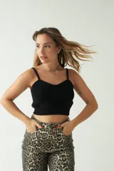 Top tejido de punto color negro, con escote corazón, breteles finos y diseño corto al cuerpo.