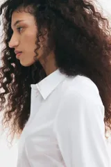 Camisa de manga larga en mezcla de algodón con cuello, botones en la parte delantera y canesú en la espalda. Cuenta con puños sencillos y bajo redondeado.