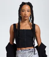 Top negro ajustado al cuerpo con escote cuadrado y breteles anchos. Presenta un cierre frontal con colchetes visibles.