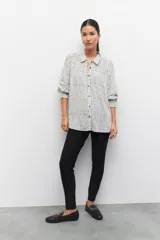 Pantalón chupín elastizado negro con cierres laterales y costuras a lo largo de ambas piernas.