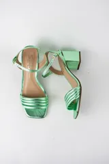 Sandalias de fiesta metalizadas color celeste, con taco cuadrado de 4 cm, tiras delanteras acolchadas y tira ajustable al tobillo con hebilla dorada.
