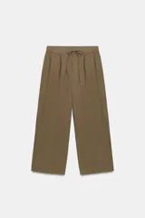 Pantalón de tiro medio con corte balloon, cintura elástica ajustable con cordones, bolsillos laterales ocultos y bolsillos de plastrón en la parte trasera.