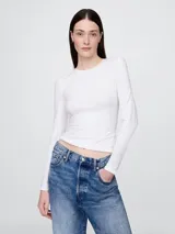 Remera de manga larga con cuello redondo, confeccionada en tejido suave y elástico, con un corte ajustado al cuerpo.