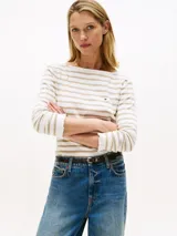 Sweater de manga larga con cuello barco y sutiles volantes en el borde. Presenta un diseño de rayas horizontales en tonos blanco y beige.