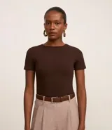 Blusa color beige de mangas cortas, confeccionada en tejido rib con textura acanalada y cuello redondo.