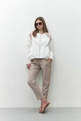 Chaqueta bomber blanca con cierre frontal, mangas largas con diseño geométrico calado en los hombros y puños elásticos.