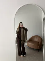 Ruana negra de tejido liviano con terminación de flecos en el ruedo y mangas amplias.