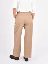 Pantalon de vestir color kaki, de corte recto y tiro alto, con pinzas frontales y bolsillos laterales.