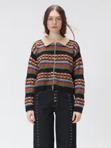 Campera de punto con cierre frontal, diseño de rayas horizontales multicolores y estampado geométrico. Presenta cuello de corderito y puños tejidos.