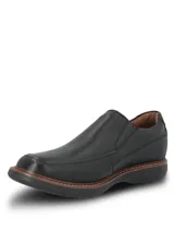 Zapato tipo mocasín Hush Puppies modelo Oregon, confeccionado en cuero negro con textura granulada. Presenta un diseño slip-on con elásticos laterales, costuras reforzadas y una suela de goma EVA que proporciona flexibilidad y aislamiento térmico.