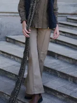 Pantalón negro de algodón, con corte recto, costura central en la pierna, bolsillos con pespuntes irregulares y pasacintos.