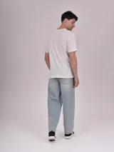 Remera manga corta color crudo con estampa rectangular con foto de calle con palmeras y texto en color fucsia.