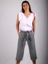 Musculosa rosa pálido con escote en V, sin mangas y con detalle de lazos en los hombros.