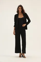 Blazer negro con estampado de lunares blancos, de corte recto y solapas clásicas.