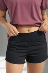 Short negro de tiro medio con corte ligeramente acampanado, confeccionado en tejido técnico de secado rápido con cintura elástica ancha.