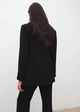 Blazer negro de corte recto, con solapas de muesca, bolsillos con solapa en los laterales y cierre frontal de un botón.