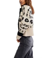 Cárdigan de punto con cuello tipo camisa y cierre frontal de botones. Presenta un diseño estampado floral en contraste sobre fondo claro, con puños y ruedo acanalados.