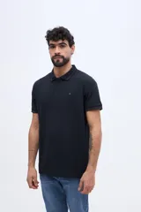 Chomba de piqué en color negro, de manga corta, con cuello y puños tejidos con líneas a contraste. Presenta cierre frontal parcial con botones y pequeño logo bordado en el pecho.